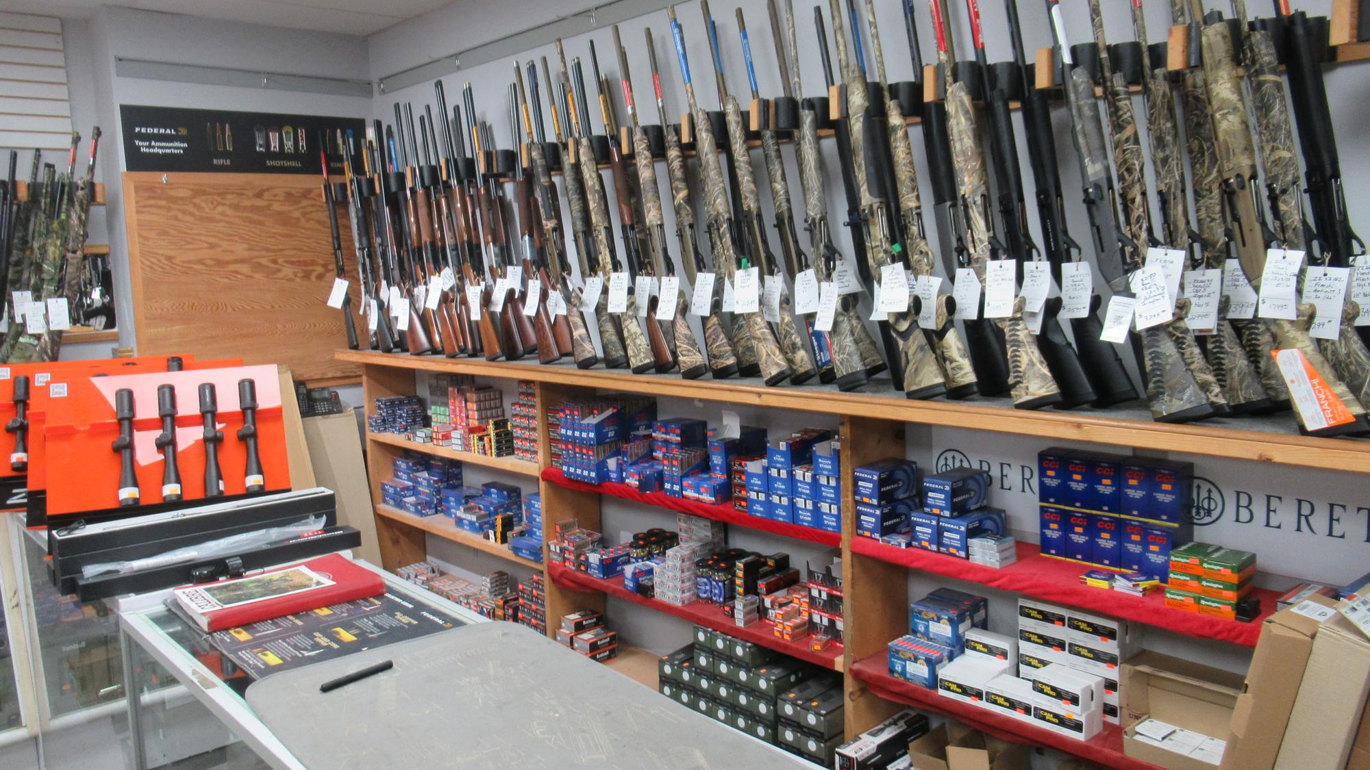 Camo shotguns above shelves of ammunition